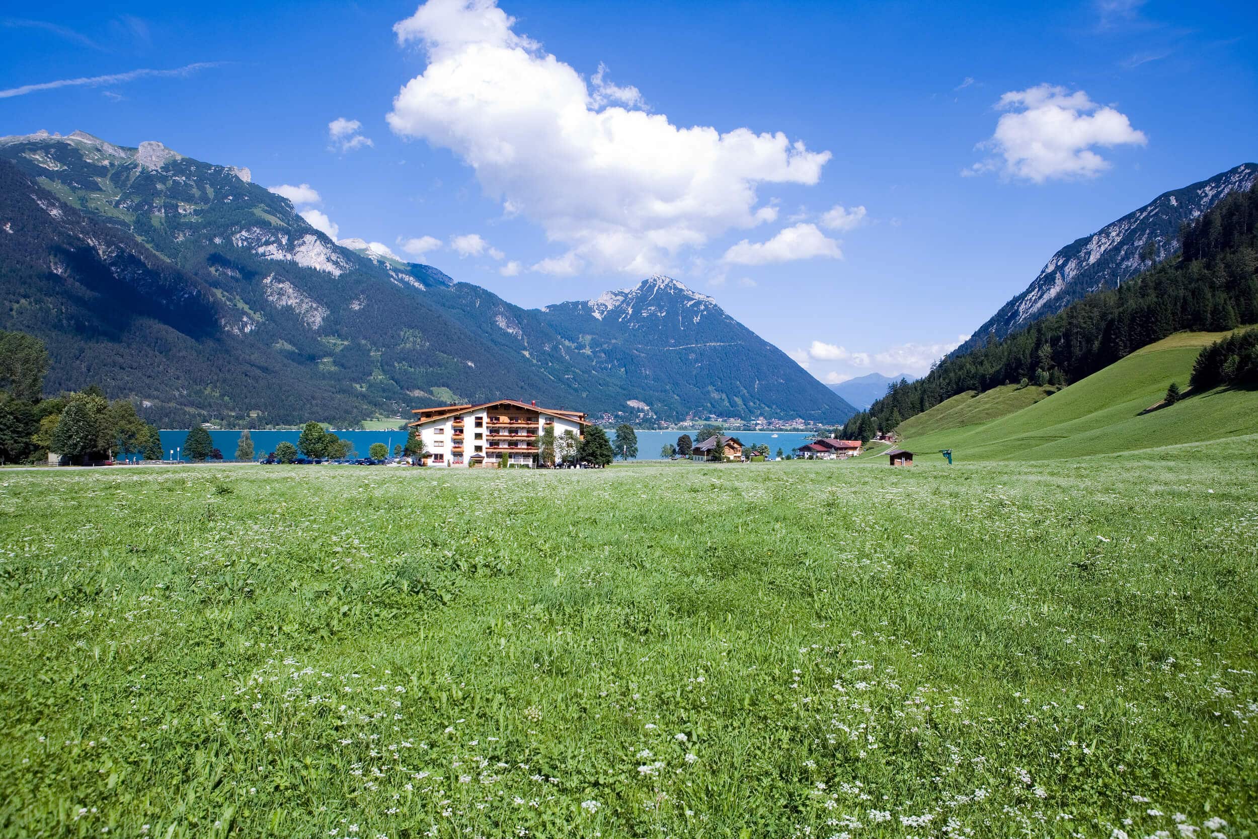 Das Hotel Bergland in einer sommerlichen Wiese - optimal für Wellness am Achensee